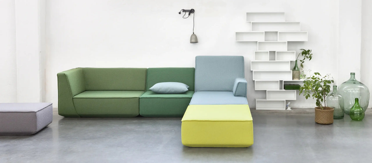 Modulares Sofa in Grün, Blau und Gelb mit weißem modularem Regalsystem im Loft.