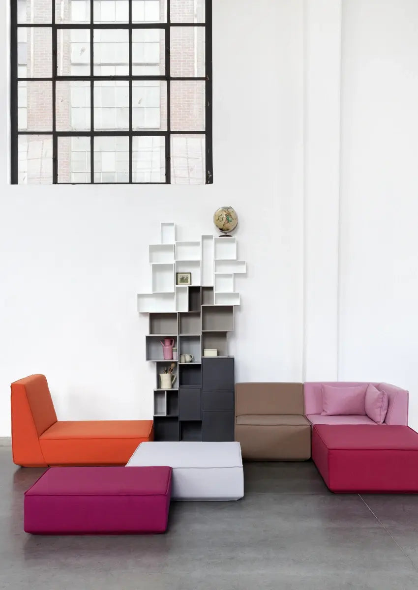 Modulares Sofa in Orange, Pink und Grau mit modularem Regalsystem im großzügigen Loft.