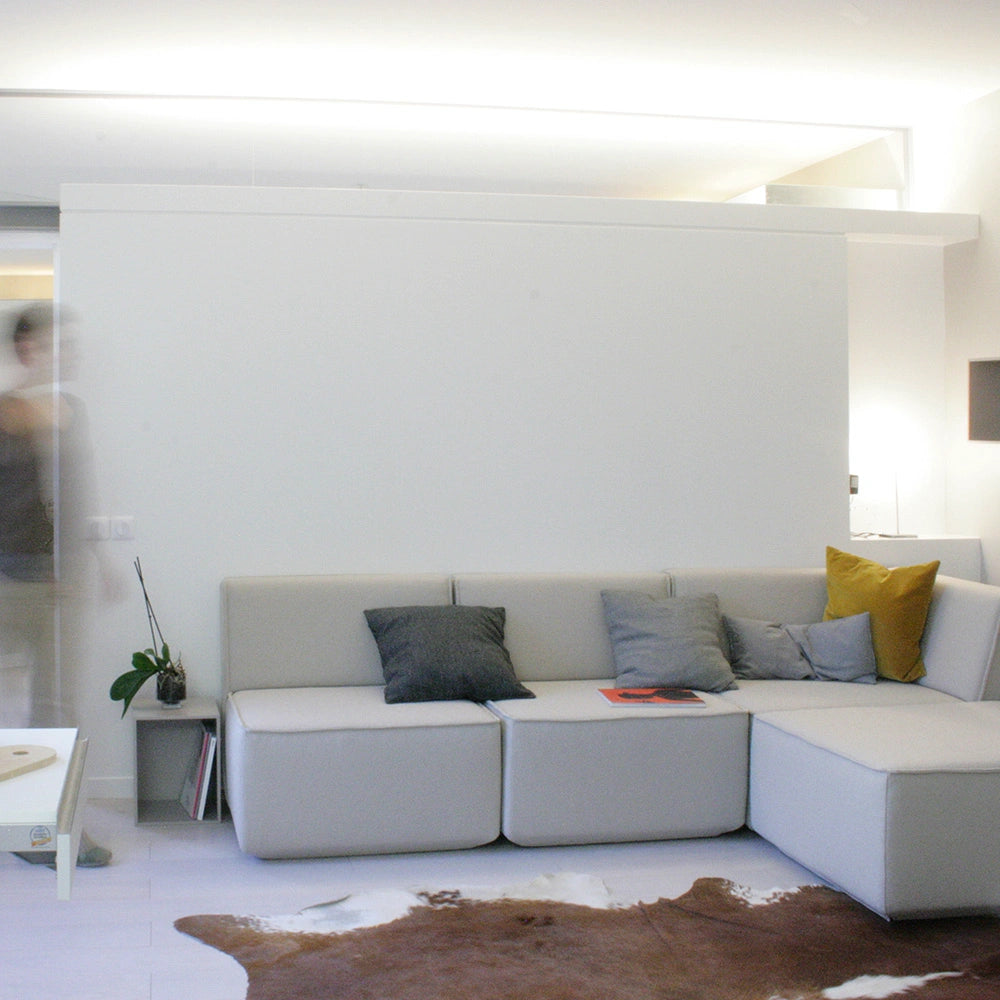 Corner sofa light-colored modular Corner sofa light gray with colorful cushions in anthracite and mustard yellow, set against a white wall in a light-filled room.