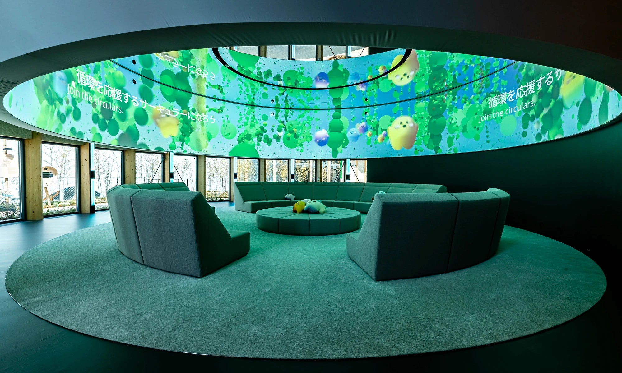 Runde Sitzlandschaft als Sonderanfertigung für eine immersive Rauminstallation auf der Weltausstellung – mit 360°-Projektionsfläche und grüner Atmosphäre.