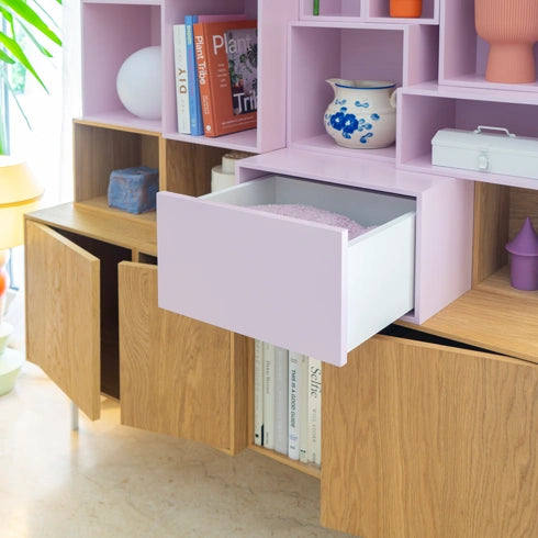 drawers Shelving in wood and pink, combined with decorations and books.