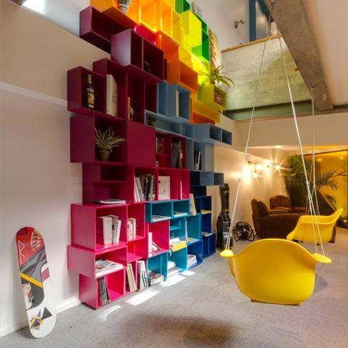 colourful modular shelving in pink, blue and yellow, combined with a swing and plants.