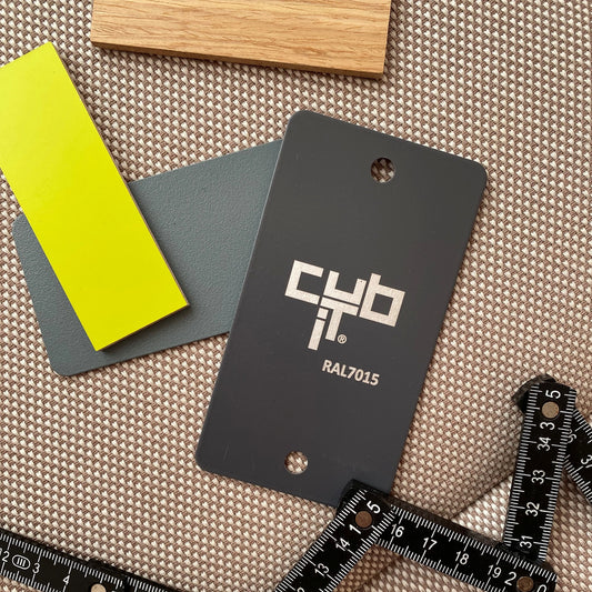 Material samples in wood, yellow and grey tones (RAL7015) on fabric background with folding rule - for customer advice