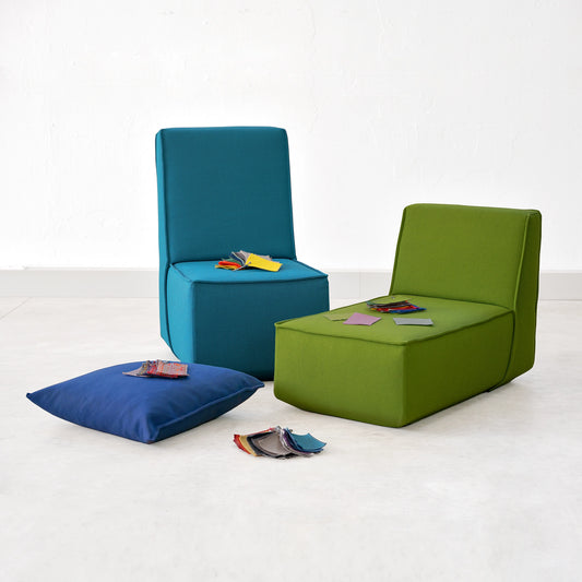 Two sofa elements in blue and green, presented with fabric samples for customers to view