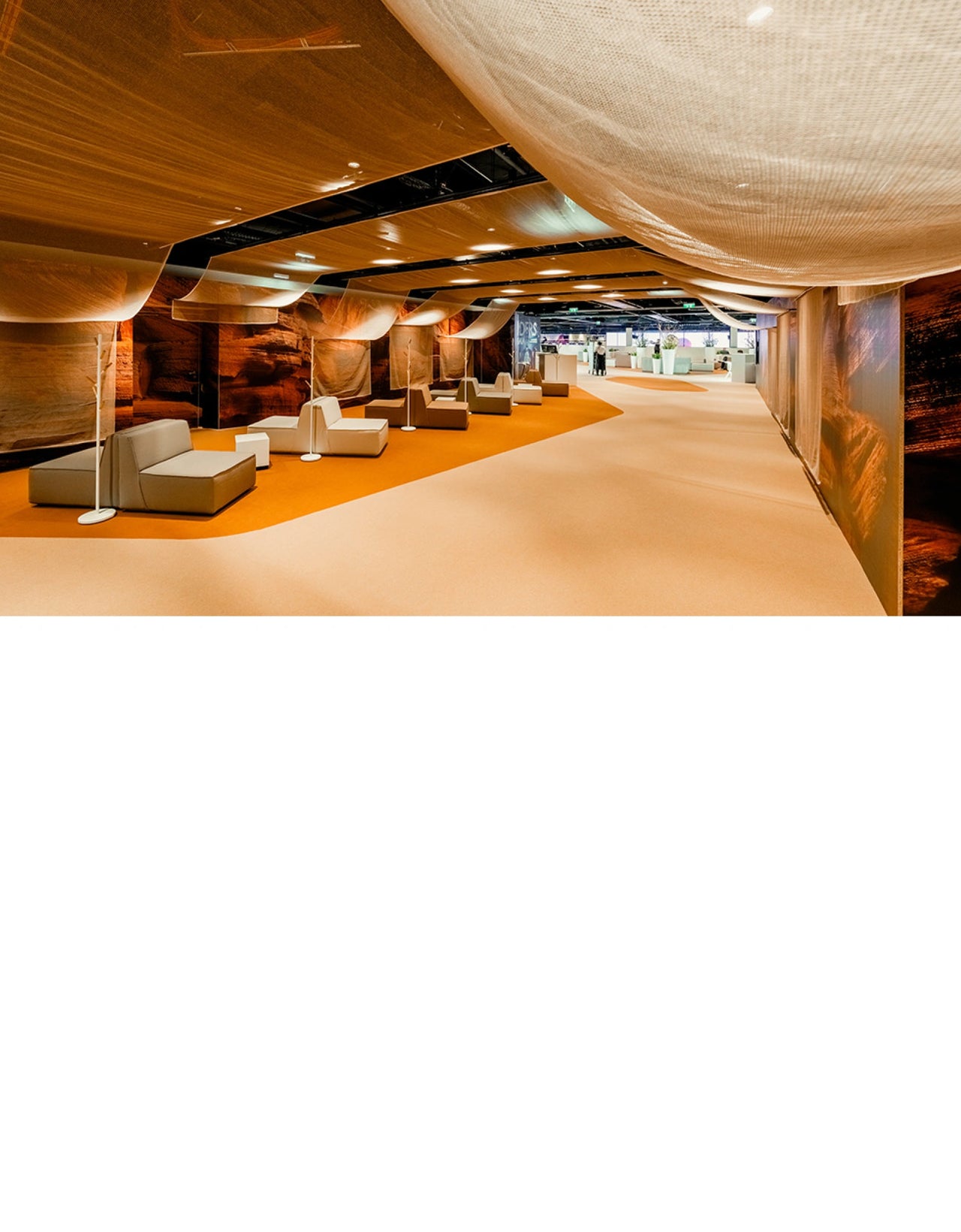 Sièges modernes aux couleurs neutres dans un vaste espace salon avec plafond textile.