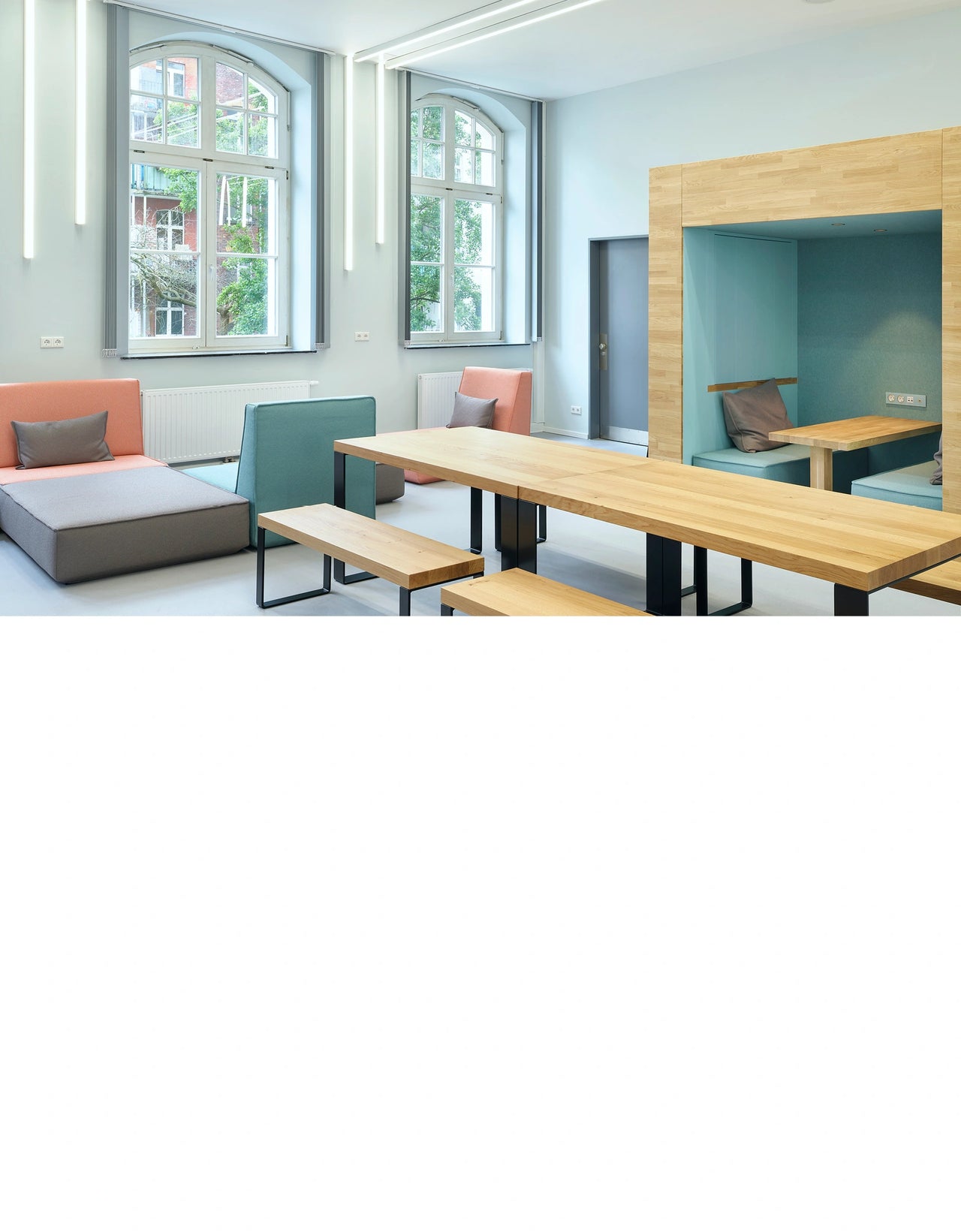 Canapé panoramique moderne Canapé panoramique modules colorés et niches intégrées dans une salle commune lumineuse d'un lycée